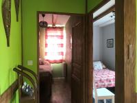 a room with green walls and a bedroom with a bed at La Petite Finlande in Orbey