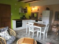 a kitchen with a table and chairs and a refrigerator at La Petite Finlande in Orbey