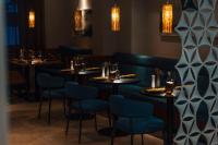 una fila de mesas en un restaurante con sillas azules en The Secret Sölden, en Sölden