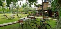 een groep tafels en stoelen met fietsen geparkeerd in het gras bij Katumbiri Resort in Bogor
