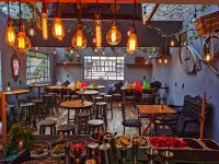 ein Restaurant mit Tischen, Stühlen und Lichtern in der Unterkunft #1 Cozy depa Aeropuerto Estadio GNP -Foro Sol- in Mexiko-Stadt