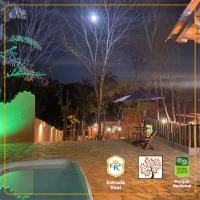a night view of a backyard with a table and an umbrella at POUSADA VILA ACONCHEGO- Sossego- Em Meio Há Mata Nativa- by MARCOS MICOZZI in Serra do Cipo