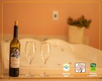 a bottle of wine sitting next to two wine glasses at POUSADA VILA ACONCHEGO- Sossego- Em Meio Há Mata Nativa- by MARCOS MICOZZI in Serra do Cipo