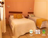 two beds in a room with orange walls at POUSADA VILA ACONCHEGO- Sossego- Em Meio Há Mata Nativa- by MARCOS MICOZZI in Serra do Cipo