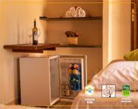 a small refrigerator in a room with a bottle of wine at POUSADA VILA ACONCHEGO- Sossego- Em Meio Há Mata Nativa- by MARCOS MICOZZI in Serra do Cipo