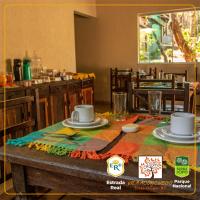 a table with plates and cups on top of it at POUSADA VILA ACONCHEGO- Sossego- Em Meio Há Mata Nativa- by MARCOS MICOZZI in Serra do Cipo