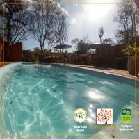 a swimming pool with blue water in a yard at POUSADA VILA ACONCHEGO- Sossego- Em Meio Há Mata Nativa- by MARCOS MICOZZI in Serra do Cipo