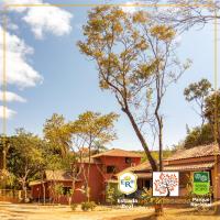 a sign in front of a building with a tree at POUSADA VILA ACONCHEGO- Sossego- Em Meio Há Mata Nativa- by MARCOS MICOZZI in Serra do Cipo