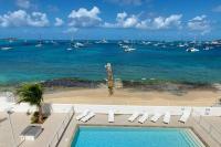 a view of the ocean and a beach with boats at Duplex moderne vue mer des caraibes in Marigot