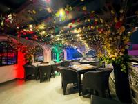 uma sala de jantar com mesas, cadeiras e luzes em Rose Palace Hotel, Gulberg em Lahore