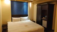 Schlafzimmer mit einem großen weißen Bett und einem blauen Fenster in der Unterkunft Bitan Hotel in Xindian