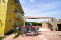 een patio met een tafel en stoelen naast een geel gebouw bij 5 States Resort in Amritsar