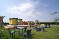 een groep tafels en stoelen in het gras bij 5 States Resort in Amritsar