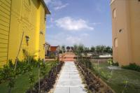 een geel gebouw met een wandelpad in een tuin bij 5 States Resort in Amritsar