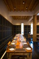 uma longa mesa de madeira num grande quarto com cadeiras em Ladakh Eco Resort em Leh