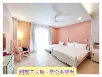 a large bedroom with two beds and a window at 城市阿瑪菲-花蓮火車站前 in Hualien City