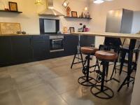 a kitchen with black cabinets and a counter with stools at Bij Sarah in Leopoldsburg