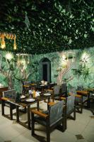 un restaurante con mesas y sillas y una pared cubierta de plantas en Asmald Palace Hotel, en Qo‘qon