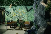 Una mesa de comedor con sillas y una pared con un mural. en Asmald Palace Hotel, en Qo‘qon