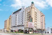Un gran edificio blanco con un cartel delante. en Harbourview Hotel Macau, en Macau