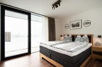 a bedroom with a bed and a large window at Apartment GIDI und LISL in Bramberg am Wildkogel