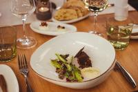 Una mesa con un plato de comida y copas de vino. en Weinzuhause Hotel-Restaurant-Vinothek, en Mommenheim