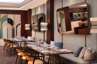 un restaurante con mesas y sillas largas y espejos en Sheraton Istanbul Levent, en Estambul