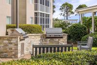 a grill and a bench in front of a building at Marriott&#39;s Legends Edge at Bay Point in Panama City Beach