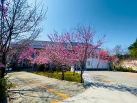 a group of trees with pink flowers in front of a building at Junyi Landscape Villa in Ren&#39;ai