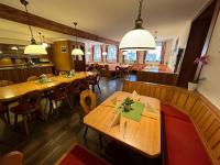 a restaurant with wooden tables and chairs and lights at Hotel-Gasthof Postbräu Dingolfing in Dingolfing