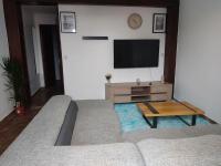 a living room with a couch and a flat screen tv at Petite maison de village in Puylaurens