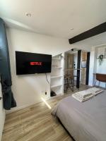 a bedroom with a television hanging on the wall at Villa Corbelle - Grand Studio in Cannes