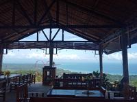 a restaurant with tables and a view of the ocean at Thornton's Sea View Cafe & Guesthouse in Siquijor