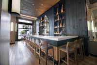 a bar in a restaurant with wooden walls and chairs at Apart Enjoy Pucón in Pucón