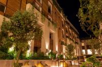 Um prédio de apartamentos à noite com mesas e árvores. em NUMU Boutique Hotel, The Unbound Collection by Hyatt em San Miguel de Allende