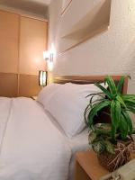 a bedroom with a white bed and a potted plant at 水社海民宿 in Yuchi