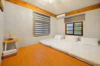 a bedroom with a white bed and a window at Li Jin Kuan Homestay in Nanzhuang