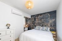 a bedroom with a white bed and a wooden wall at Superbe T2 Juan Les Pins 300m des plages in Antibes