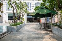 een patio met een groene parasol en een tafel bij Cozrum Homes - Sonata Residence in Ho Chi Minh-stad
