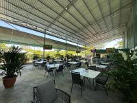 um restaurante com mesas e cadeiras sob um dossel em Hotel Cabinas el Tecal em Uvita