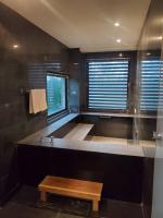 a black bathroom with a tub and a wooden bench at Fu Wan Cafe Villa in Donggang