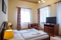 a bedroom with a bed and a desk and a television at Hostel Little Quarter in Prague