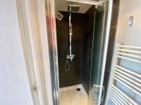 a shower with a glass door in a bathroom at P&#39;tite maison du Parc in Orléans