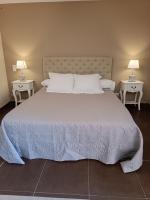 a bedroom with a large bed with two tables at Aux Berges du Canal in Capestang