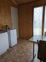 a kitchen with white appliances and a table and a window at Au petit chalet d&#39;Illiers Combray in Illiers