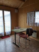a table and two chairs in a room with wooden walls at Au petit chalet d&#39;Illiers Combray in Illiers