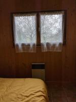 a bedroom with two windows and a bed in it at Au petit chalet d&#39;Illiers Combray in Illiers