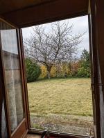 a window view of a field with a tree at Au petit chalet d&#39;Illiers Combray in Illiers