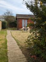 a house with a table and a bench in a yard at Au petit chalet d&#39;Illiers Combray in Illiers