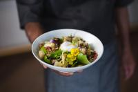 una persona sosteniendo una ensalada en un tazón blanco en Carnmore Hotel Christchurch, en Christchurch